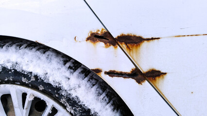 Sheet metal corrosion of old white car. Rusty messy surface. Damaged grunge dirty texture from road...