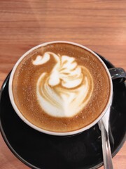 Portrait of a beautifully decorated latte coffee with whipped cream topping from a café