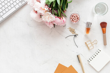 Home office workspace with female accessories and peony flowers