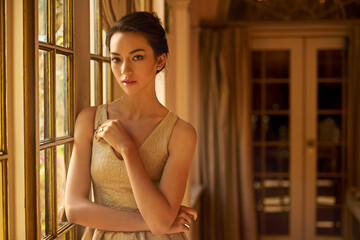 Fototapeta premium Fashion, window and portrait of elegant woman in home for gala event in style, classy outfit and dress. Wealth, aesthetic and person with confidence, pride and glow in vintage manor, house or mansion