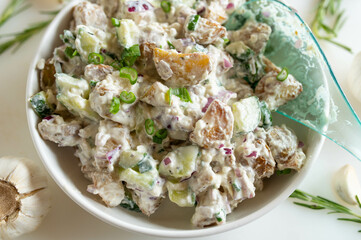 Healthy summer salad with roasted potatoes, cucumber, onions, chives and feta cheese