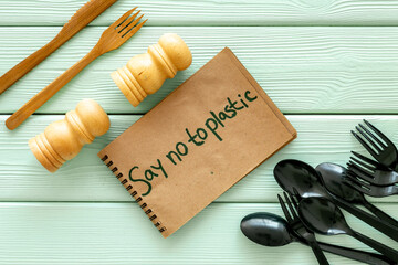 Eco friendly wooden and harmful plastic cutlery with Say no to plastic sign. Zero waste concept