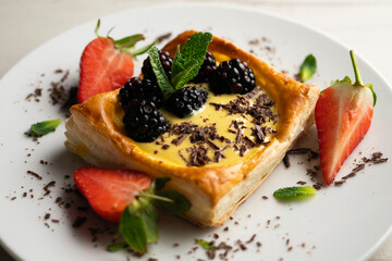 Puff pastry dessert with strawberries and blackberries filled with pastry cream.