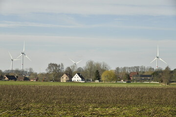 Groupe d'éoliennes émergeant d'un paysage rural à ghislenghien