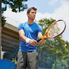 Man, racket and serve in outdoor tennis match, game and court for competition or practice. Male person, athlete and ready for training or exercise, workout and hobby for action and play fitness