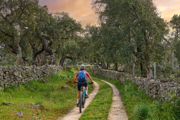 Fototapeta na wymiar active senior woman cycling with her electric mountain bike in the rough landscape of National Parc Serra de São Mamede near Marvao in central Portugal, Europe