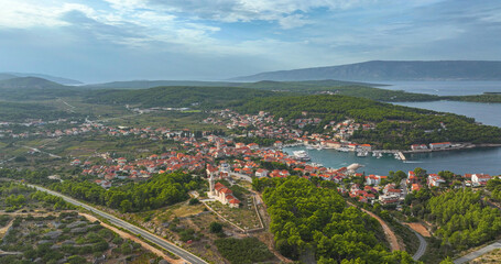 AERIAL: Flying over the lush greenery and towards the scenic marina of Hvar.
