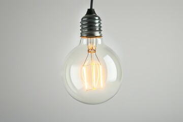 Vintage light bulb with a soft glow against a transparent white backdrop, ideal for retro designs