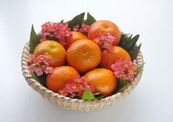Mandarin fruit with leaves, kalanchoe flowers, on woven basket,othe mandarin orange, Citrus reticulata
