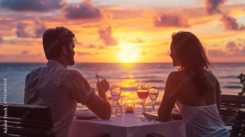 Wall mural a couple celebrating their anniversary with a romantic dinner at sunset - Wall murals