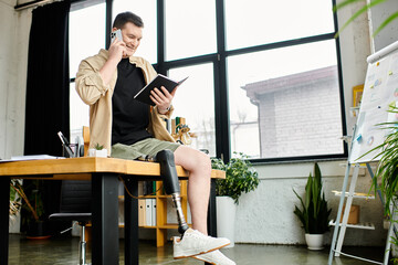 A handsome businessman with a prosthetic leg sits at a table, talking on a cell phone.