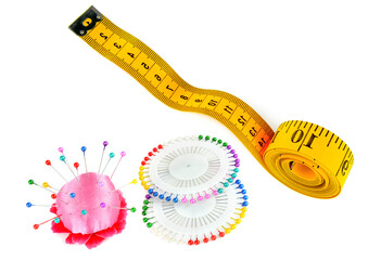 Measuring tape, sewing pinsand pincushion isolated on white. There is free space for text. Collage.