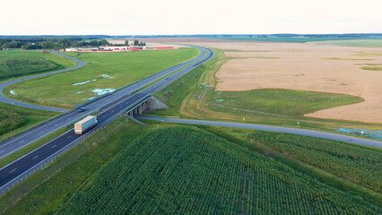 Long haul semi truck driving on intercity highway bridge in rural region. Agricultural grain corn...