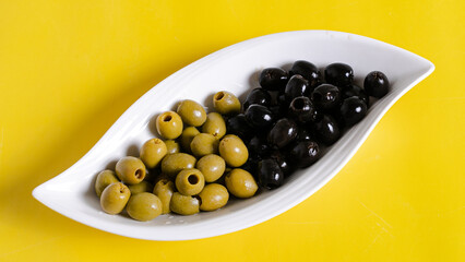 Black and green olives top view isolated on yellow