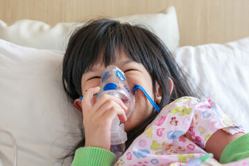 Sick little asian girl inhalation with nebulizer for respiratory treatment - 795402654