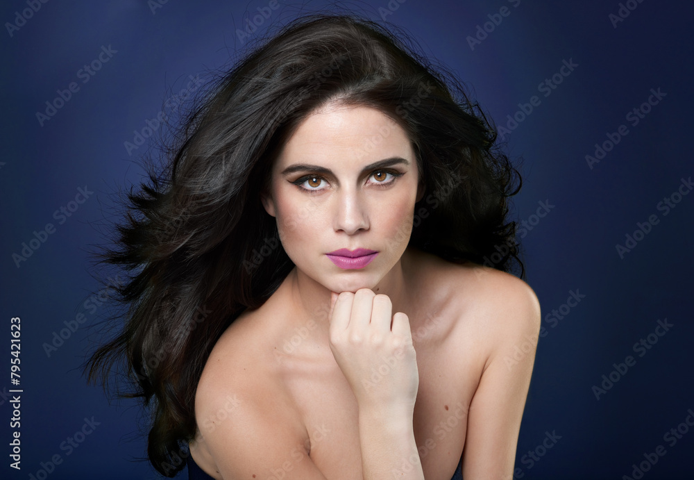 Wall mural Woman, portrait and beauty makeup or confident in studio on blue background or self care, cosmetology or mockup space. Female person, model and serious face or skincare glamour, treatment or facial