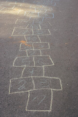 Chalk drawings on asphalt. Hopscotch game concept. Childhood concept. Painted numbers on the road. Outdoor games. Children activity. Outdoor playground in the city. Colourful hopscotch line. - 795422820
