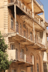 Elaborate traditional facade with many balconies on an apartment building in the old town of Mardin, Turkey