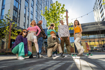 A Vibrant Group Of Young Adults In Stylish Urban Attire Poses Dynamically On A City Street, Exuding...
