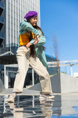 Young Asian Woman In Colorful Outfit Dancing On Urban Water Feature With Modern Buildings In Background, Captured In Bright Daylight. Perfect For Fashion And Lifestyle Themes. Vertical Screen.