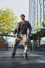 Vertical Screen: A Young Caucasian Man In Stylish Outfit Performs An Energetic Breakdance Or Hip-Hop Move In A Sunny, Urban Plaza, Showcasing Youth, Culture, And The Art Of Street Dancing Alone
