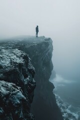 b'Man standing on a cliff overlooking the ocean' - obrazy, fototapety, plakaty