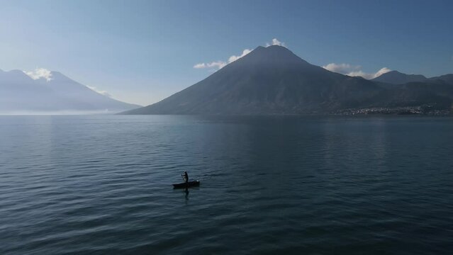 Aerial video of a man in a traditional boat on Lake Atitlan in Guatemala