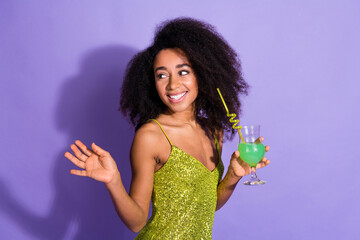Photo portrait of gorgeous young girl hold cocktail look empty space wear trendy green sequins outfit isolated on purple color background - obrazy, fototapety, plakaty