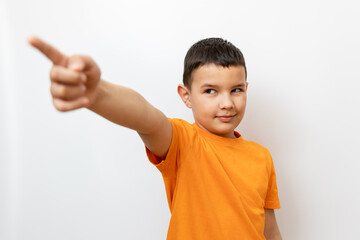 A cheerful guy in an orange t-shirt extends his hand with an index finger. Sincere children's...