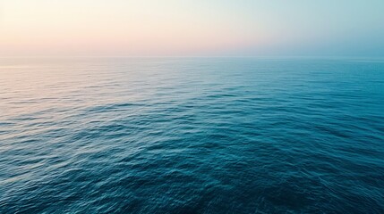 Obraz premium An aerial view of a calm sea at dawn, the subtle gradient of blues creating a tranquil, minimalist landscape that invites contemplation.