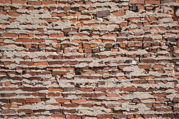 Wall of hand-made red bricks and rough mortar.