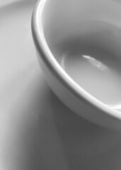 An empty white bowl on a white surface creating a white on white photo