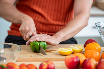 Hand chef knife cut and slice fresh Vegetables baby cos salad on wood board table .Make Salad Organic Vegetables mix lunch with green vegetables and fruit at kitchen table on wood cutting board.