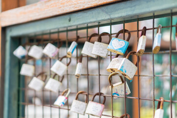 A close up of love padlocks attached to a railing