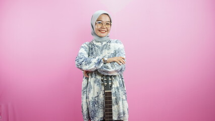Indonesian Muslim woman guitar on a pink background