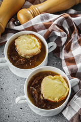 delicious original French onion soup on a light stone background