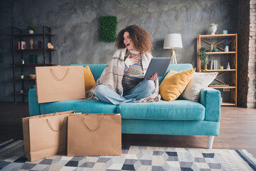 Photo of charming lovely woman dressed trendy clothes sitting on soft sofa in cozy apartment indoors
