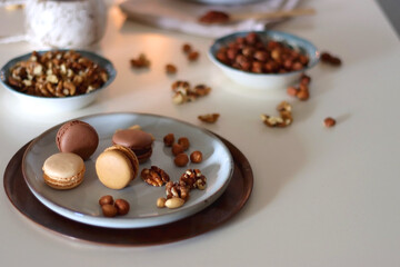 Cup of tea or coffee, cookies, macaroons, chocolate, various nuts and cocoa powder on white background. Selective focus.