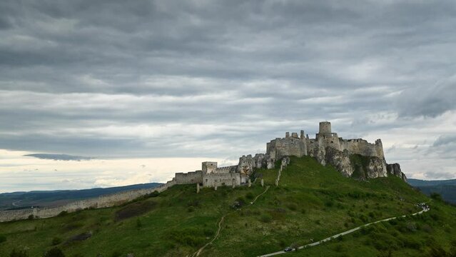 Timelapse of Spissky Hrad Castle in Slovakia with clouds and tour group ascending the path to the castle. Ruins of medevial castle Spiš Castle in eastern Slovakia. 