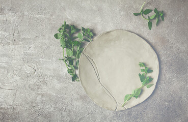 grey clay plate, handmade, with basil branches, top view, food background, food wallpaper for menu,