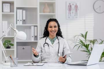 A professional Hispanic woman, working as a doctor, smiling while discussing health care solutions...