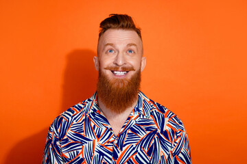 Photo of dreamy funky guy dressed print shirt looking up empty space isolated orange color background