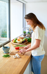 Smile, home and woman with vegetables, cutting and salad with organic ingredients, healthy meal and food. Wellness, vegetarian and person in kitchen, nutrition and diet with knife, cooking and chef