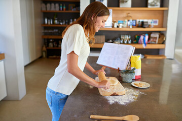 Baking, home and woman with recipe, book and smile for lunch with flour, dough and rolling pin....