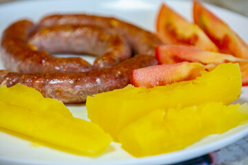 Traditional rustic Brazilian food, sausage with cassava and tomatoes