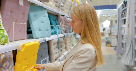 Young woman designer choosing cushions for chairs