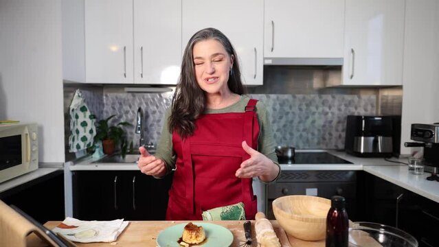 A senior vlogger records traditional cooking recipe tutorials in her kitchen