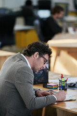 Man, notebook and writing with planning by desk for daily schedule, brainstorming and idea for...