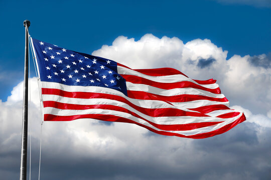 American flag on blue sky with beautiful clouds