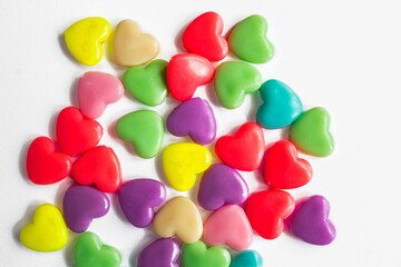 Multi-colored plastic hearts on a white background. Background for Valentine's day